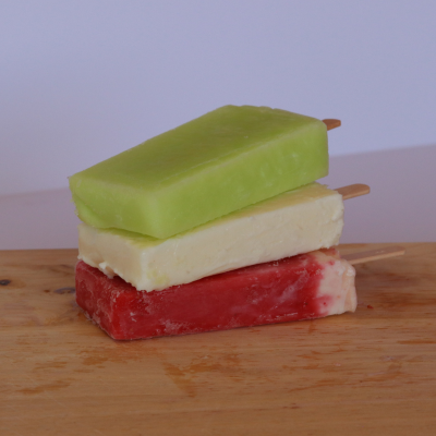 Three stacked paletas de agua in lime, pineapple, and Watermelon flavors – traditional Mexican ice cream treats